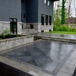 Expansive front entrance with raised bed gardens on this new home